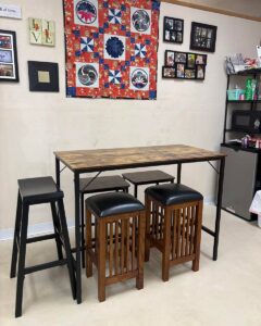 Back office break room area with tall table and barstools
